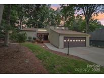 Charming exterior view of a home with a two-car garage and a neatly landscaped front yard at 8117 Rising Meadow Rd, Charlotte, NC 28277