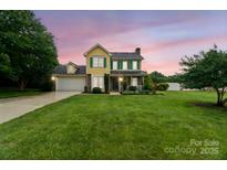 Charming two-story home with a well-manicured lawn and colorful sunset backdrop, creating a welcoming curb appeal at 105 Carmel Hills Dr, Gastonia, NC 28056