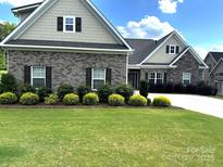Charming two-story home with a well-manicured lawn and attractive landscaping, including shrubs and trees at 1108 Tarram Ct # 12, Lancaster, SC 29720