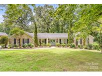 Charming brick home featuring a welcoming double door entry, well-manicured landscaping, and mature trees at 120 Labans Ln, Lincolnton, NC 28092
