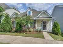 Charming home featuring a stone and vinyl exterior, manicured lawn, and inviting front porch at 16508 Landen Forest Ln, Davidson, NC 28036