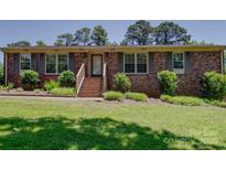 Charming brick home with shutters, landscaped front yard, and inviting steps leading to the entrance at 1830 Huntington Pl, Rock Hill, SC 29732