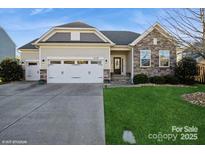Charming single-Gathering home featuring a stone facade, two-car garage, and well-maintained landscaping at 2112 Balting Glass Dr, Indian Trail, NC 28079