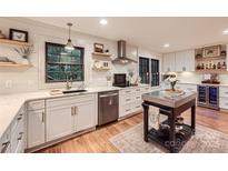 Bright kitchen features white cabinets, stainless appliances, shiplap walls and butcher block island at 3214 Tilley Morris Rd, Matthews, NC 28105