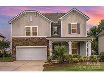 Charming two-story home with stone accents, lush landscaping, and an attached two-car garage at 463 Hunton Forest Nw Dr, Concord, NC 28027