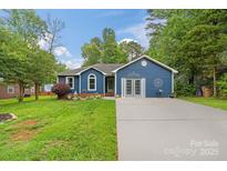 Charming blue single-story home with manicured lawn, and a welcoming driveway leading to the front entrance at 4810 Shea Ct, Monroe, NC 28110