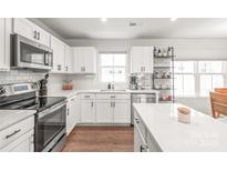 Modern kitchen featuring white cabinets, stainless steel appliances, and a stylish subway tile backsplash at 5023 Daybell St, Charlotte, NC 28214