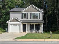 Charming two-story home with well-manicured lawn, attached garage, and inviting front porch with rocking chairs at 507 Newsome Rd, Salisbury, NC 28146