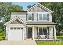 Charming two-story home featuring gray siding, black shutters, inviting front porch with rocking chairs and attached one-car garage at 507 Newsome Rd, Salisbury, NC 28146