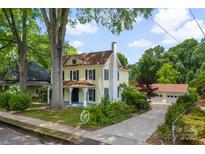 Charming two-story home with a manicured lawn, mature trees, and a detached garage at 522 Alexander St, Statesville, NC 28677