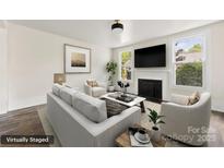 Bright living room featuring a fireplace, large windows, and stylish neutral furniture at 522 Alexander St, Statesville, NC 28677