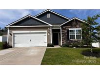 Charming single-story home showcasing a stone facade, two-car garage and well-manicured lawn at 640 Yellow Birch Dr, Locust, NC 28097