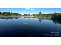 Picturesque lake view with lush greenery reflected in the still, blue water at 7204 E 218 Hwy, Marshville, NC 28103