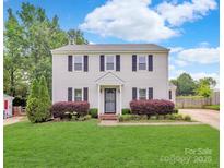 Charming two-story home featuring a well-manicured lawn and traditional design with black shutters at 10945 Wiltshire Ln, Charlotte, NC 28262