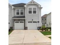 Charming townhome with a two-car garage, stone accents, and well-maintained landscaping at 13327 Savaine St, Charlotte, NC 28278
