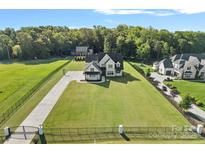 Expansive aerial view of a luxurious home with a large, well-manicured lawn and a gated entrance at 1405 Waxhaw Marvin Rd, Waxhaw, NC 28173