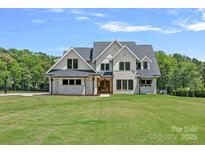 Beautiful two-story home with brick accents, complemented by a lush green lawn and mature trees at 1405 Waxhaw Marvin Rd, Waxhaw, NC 28173