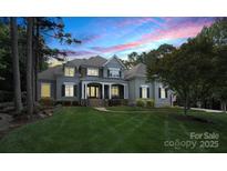 Elegant home with manicured lawn, stone accents, covered porch and stunning evening sky backdrop at 167 Quaker Rd, Mooresville, NC 28117
