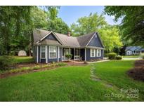 Charming home with a well-maintained lawn, stone walkway, and mature trees at 172 Valleybrook Dr # 8, Denver, NC 28037