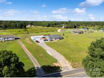 Expansive aerial view of a charming home with a long driveway, lush green lawn, and a large garage at 2268 Westbrook Rd, Edgemoor, SC 29712