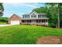 Charming two-story home featuring a welcoming front porch and well-manicured lawn at 2728 Touchstone Cir, Newton, NC 28658