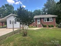 Charming red brick home features a landscaped front yard, and a covered side carport at 286 Southside Rd, Rock Hill, SC 29730