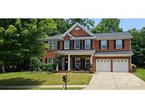 Charming two-story brick home featuring a well-manicured lawn and an attached two-car garage at 35 Dorie Dr, Belmont, NC 28012
