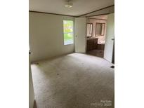Bright bedroom featuring neutral carpet, a window and open doorway to the en-suite bathroom at 4006 Hillview Dr, Shelby, NC 28152