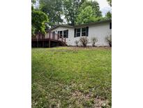 White vinyl siding home featuring a wood deck and black shutters on the front-facing windows at 4006 Hillview Dr, Shelby, NC 28152