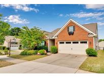 Charming, well-maintained brick home featuring a two-car garage and beautifully landscaped front yard, enhancing curb appeal at 417 Brier Knob Dr, Fort Mill, SC 29715