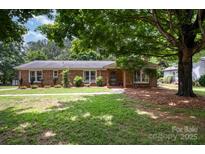 Charming brick home with a well-maintained lawn and mature trees in a peaceful neighborhood at 418 Melody Ln, Shelby, NC 28152