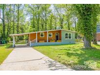 Charming single-story home featuring a welcoming front porch, covered parking, and beautifully landscaped front yard at 4524 Cinderella Rd, Charlotte, NC 28213