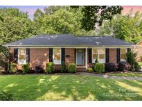 Charming brick home with manicured lawn, lush landscaping, and inviting curb appeal at 4924 Farm Pond Ln, Charlotte, NC 28212
