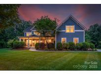 Charming two-story home with a welcoming front porch, landscaped yard, and professionally maintained lawn at 5044 Dockside Ct, Matthews, NC 28104