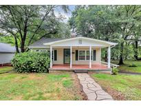 Charming home with a welcoming front porch, walkway, and lush landscaping at 613 N Rhyne St, Gastonia, NC 28054
