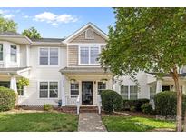 Charming two-story home featuring white siding, decorative shutters, and a welcoming front porch with manicured landscaping at 6518 Point Comfort Ln, Charlotte, NC 28226