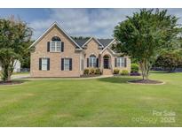 Charming brick home featuring a manicured lawn, mature trees, and classic black shutters at 736 Creekbridge Dr, Rock Hill, SC 29732