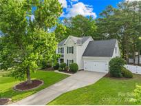 Beautiful two-story home with a well-manicured lawn, mature trees, and a two car attached garage at 8020 Sheckler Ln, Matthews, NC 28104