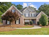 Charming two-story brick home with manicured front lawn and inviting entryway at 9219 Whispering Wind Dr, Charlotte, NC 28277