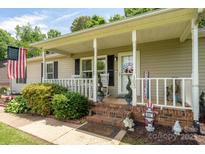 Charming front porch with rocking chairs and patriotic decorations, creating a welcoming entrance at 103 Poplar Trl, Rockwell, NC 28138