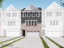New townhome showcasing a brick and gray facade, attached two car garage, and modern architectural details at 1041 Bandon Dr, Waxhaw, NC 28173