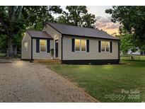 Well-maintained home with fresh landscaping and a gravel driveway at 1055 Laurel Ave, Lancaster, SC 29720