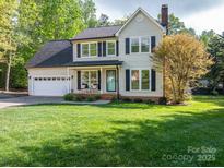 Charming two-story home featuring a well-manicured lawn, attached garage, and inviting front porch at 107 Ingonish Dr, Gastonia, NC 28056