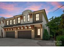 Charming brick townhome showcasing garage doors and a meticulously designed facade at 1160 S Kings Dr, Charlotte, NC 28207
