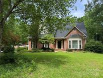 Charming brick home featuring a well-maintained lawn and mature trees providing ample shade and curb appeal at 1750 Trellis Dr, Rock Hill, SC 29732