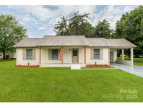 Charming single-story home with a manicured lawn, painted brick, and a covered front porch at 2040 Stratford Dr, Conover, NC 28613