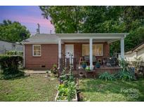 Charming brick home with a covered porch and small garden area at 2217 Tate St, Charlotte, NC 28216