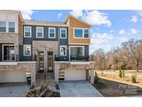 Contemporary townhome featuring mixed material facade, balcony, and a two-car garage at 3321 Treble Ct, Charlotte, NC 28262