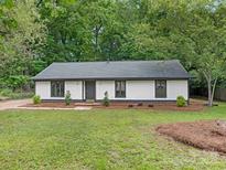 Charming single-story home with fresh white paint, dark trim and green lawn at 406 Wilcrest Dr, Matthews, NC 28105