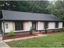 Charming ranch-style home with white siding, black trim, and decorative cedar shutters at 406 Wilcrest Dr, Matthews, NC 28105